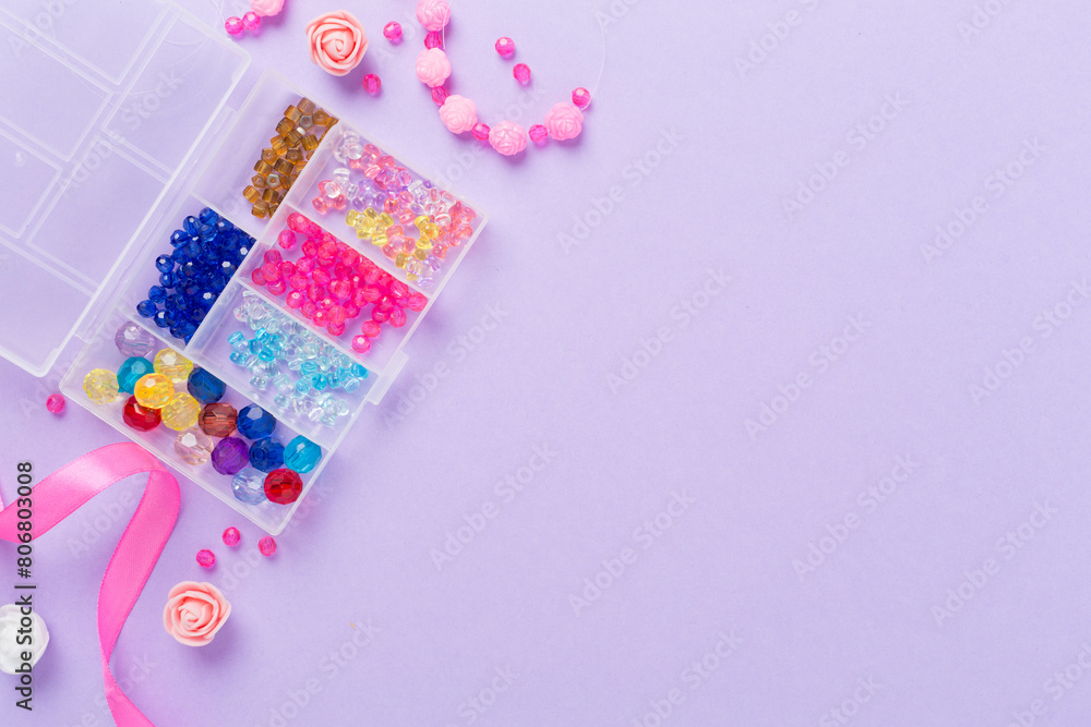 Tools and beads for making handmade jewelry on color background, top view Tools and beads for making handmade jewelry on color background, top view