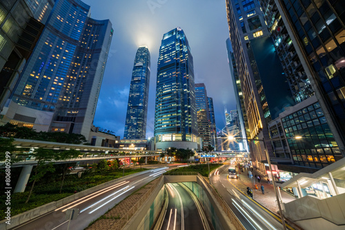 Skyscraper buildings and traffic on road with blurred cars light trails at night, Hong Kong, China