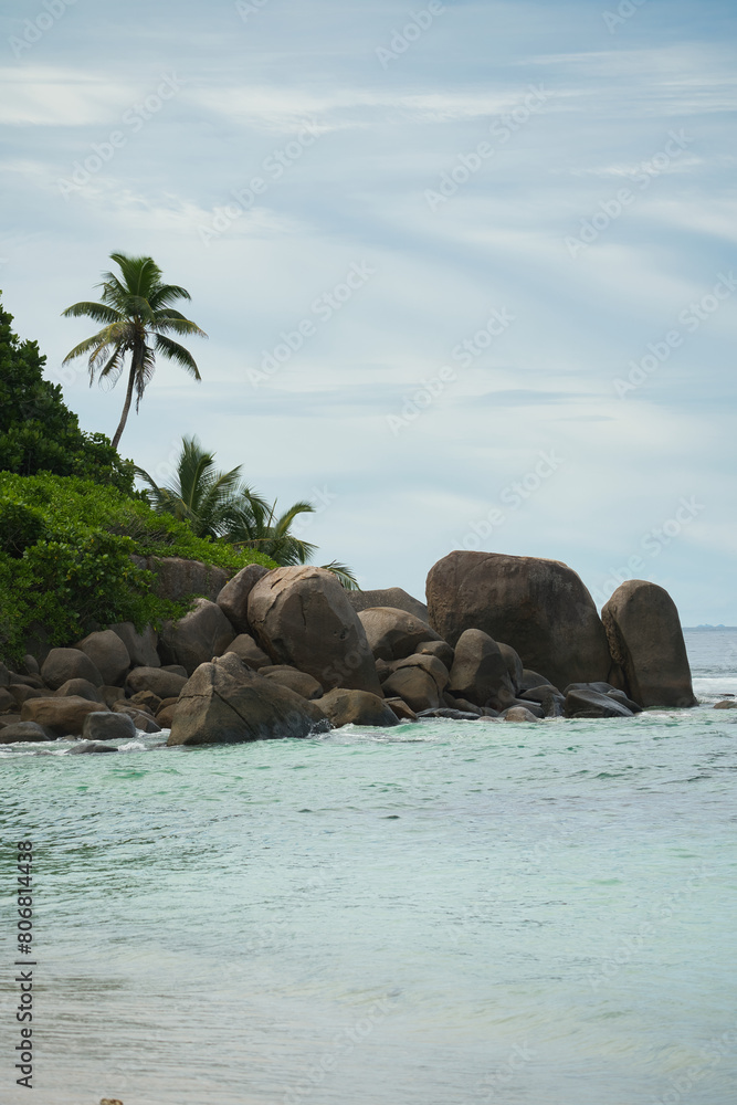 Granite stones and trees near white sandy beach of anse forbans, Calm sea, Mahe Seychelles Granite stones and trees near white sandy beach of anse forbans, Calm sea, Mahe Seychelles