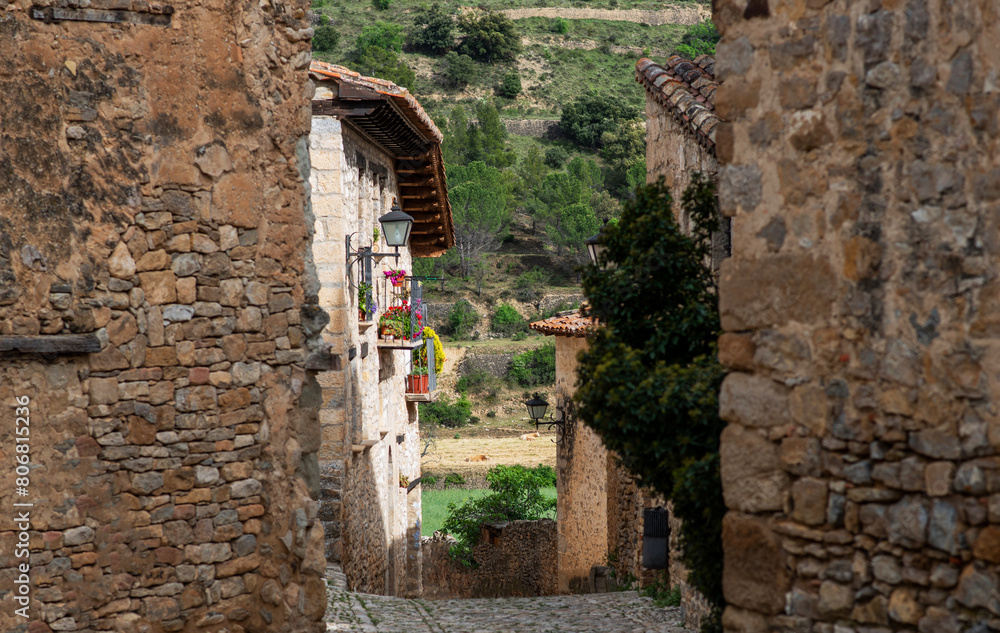 Fototapeta premium Old stone walls and cobbled narrow cozy street of a medieval village in Provence, France. View of traditional old stone houses.