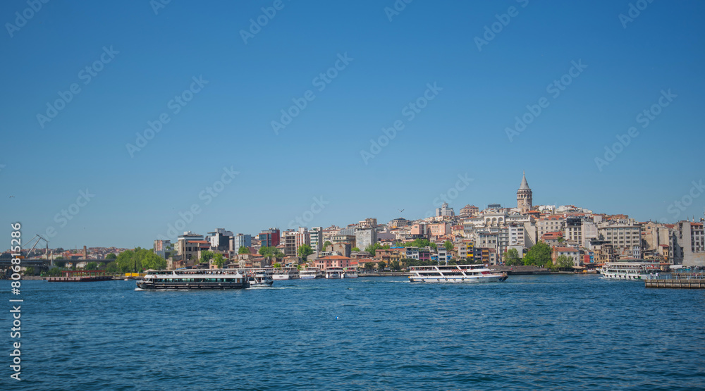 Touristic sightseeing ships in Golden Horn bay against blue sky and clouds. Istanbul, Turkey. During sunny summer day.