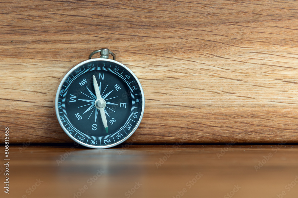 Compass on wooden background with copy space using as direction Compass on wooden background with copy space using as direction