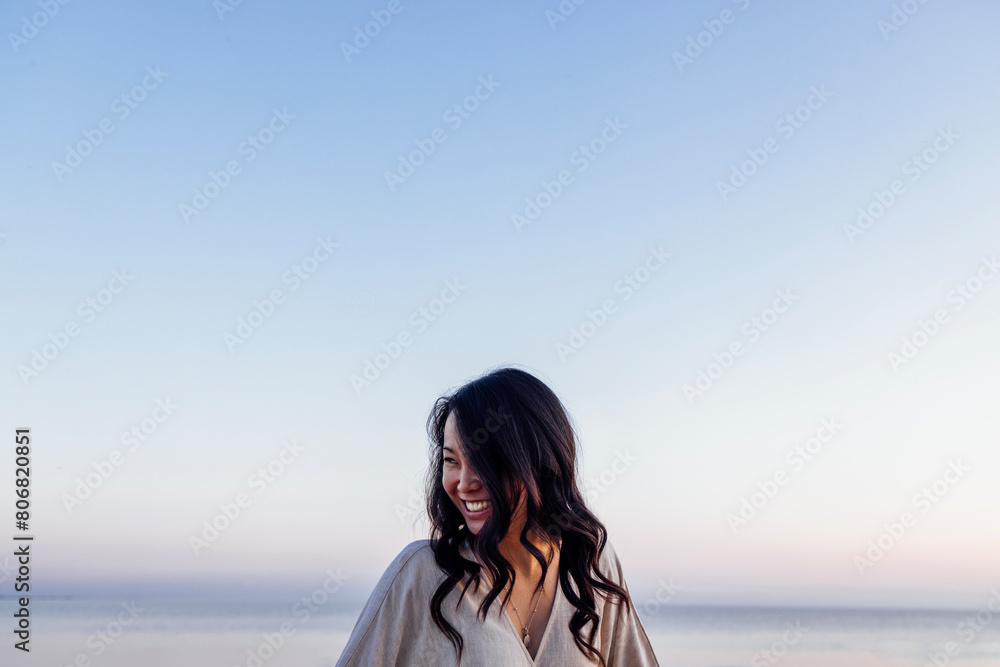 Young attractive Asian with long wavy hair outdoors. A charming Korean woman Young attractive Asian with long wavy hair outdoors. A charming Korean woman