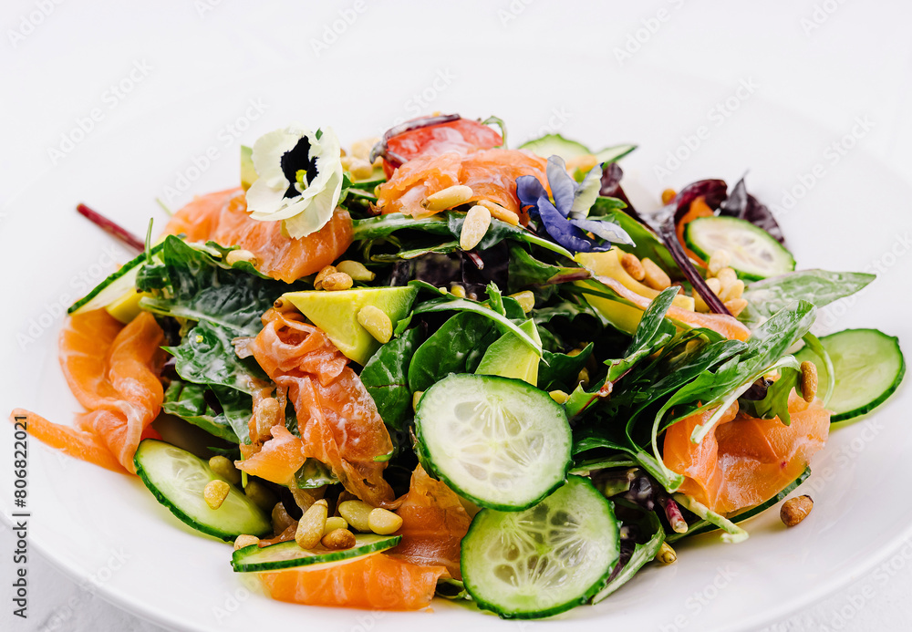 Fresh salmon and spinach salad on white plate Fresh salmon and spinach salad on white plate