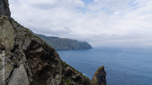 View of the Atlantic coast near the Cabo Ortegal lighthouse on the coast of Galicia, Spain, Europe. Flowering spring coastal plants. Majestic coastline looking the Atlantic Ocean. photo