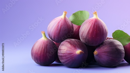 A vibrant pile of purple figs contrasting with a green leaf