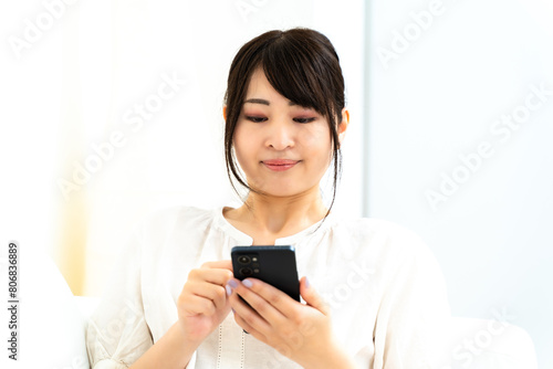 自宅でスマホを触る女性