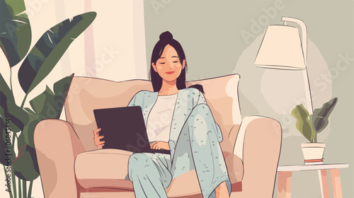 Young Asian woman in pajamas with laptop sitting