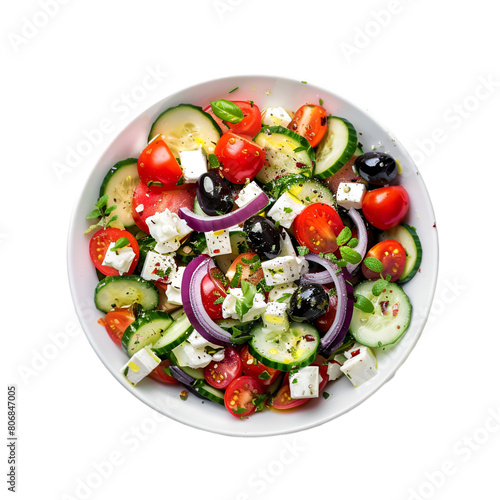 A bowl of fresh Greek salad ingredients is dropped onto a white background. 