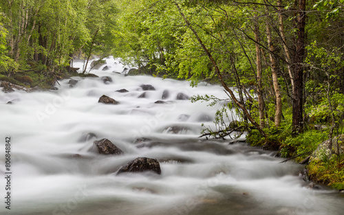 Idyllic mountain river with fresh water flowing over rocks. Pure nature in Norway.