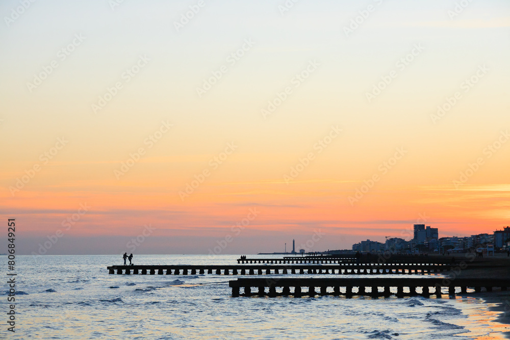 Fototapeta premium Beach at dawn, piers perspective view