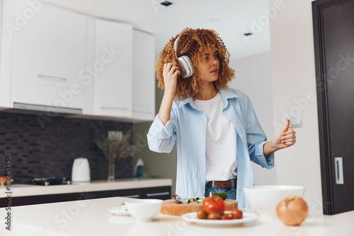 Woman standing in kitchen with cup of coffee and plate of food in hand  ready for a morning meal
