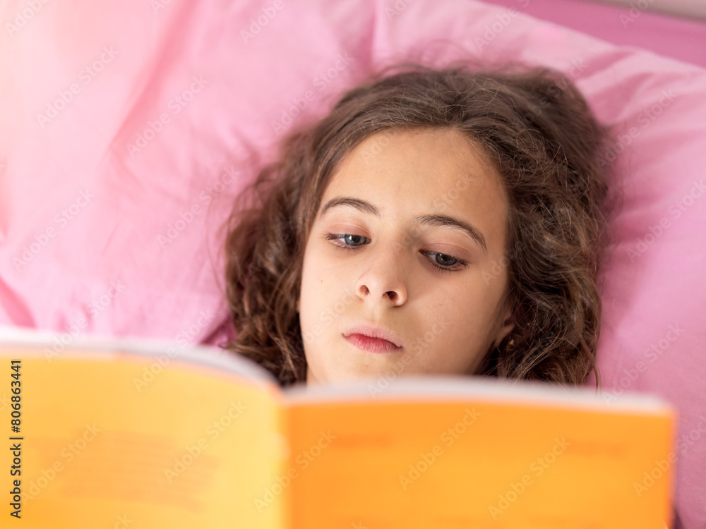 Young girl Reading Book in pink Bed Young girl Reading Book in pink Bed