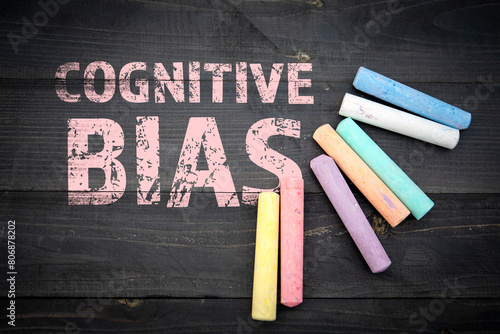 Cognitive Bias. Text and pieces of chalk on a dark wood texture background