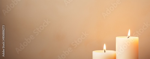 Beige background with white thin wax candle with a small lit flame for funeral grief death dead sad emotion with copy space texture for display 