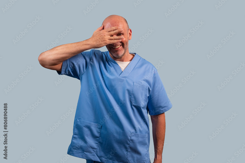 Portrait of a female physiotherapist wearing light blue dress and hands covering her face. Portrait of a female physiotherapist wearing light blue dress and hands covering her face.