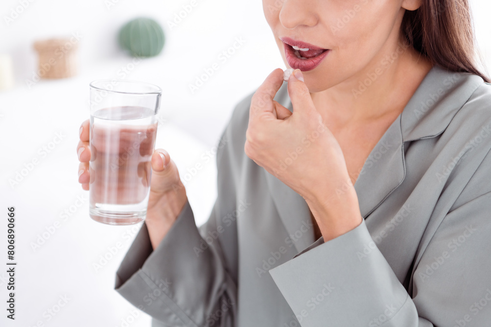 Cropped photo of shiny sweet lady grey sleepwear drinking pills water indoors home bedroom Cropped photo of shiny sweet lady grey sleepwear drinking pills water indoors home bedroom