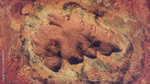 Aerial top down view of Uluru also known as Ayers Rock is a large sandstone monolith near the centre of Australia listed as a UNESCO World Heritage Site and popular tourist destination 4k animation