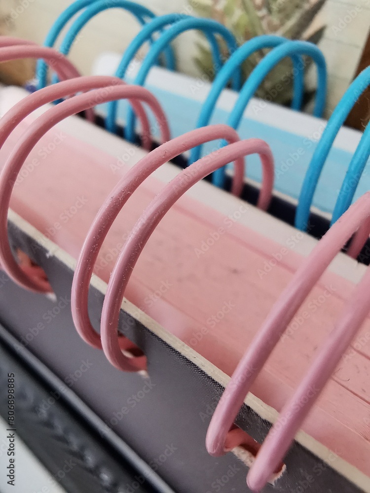 Close-up of note books with rings in blue and pink color. Close-up of note books with rings in blue and pink color.