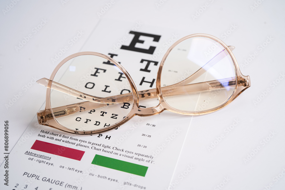 Glasses on eye testing exam chart to check eyesight accuracy of reading. Glasses on eye testing exam chart to check eyesight accuracy of reading.