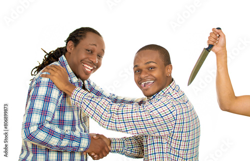 Fake friend backstabbing concept. Portrait hypocrite, crafty man gives handshake to a guy at same time trying to stab him in back with knife isolated white background.  photo