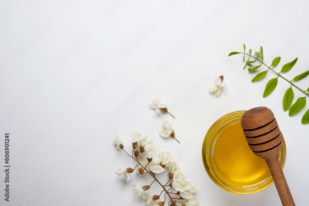 Acacia honey in a jar. Leaves and flowers of acacia tree. Freshly acacia honey. Top view, flat lay. Copy space.