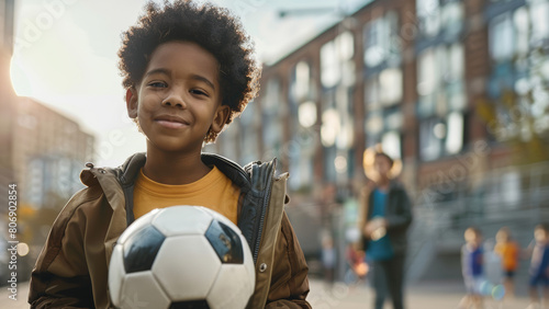 A confident young boy with a soccer ball, ready to play.