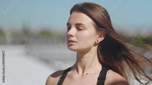 Close portrait of a woman, model, with closed eyes, hair flying, skin, care, beauty, glamour, cover, magazine, health and youth, confidence, femininity, roof, lifestyle, meditation, breathing, peace