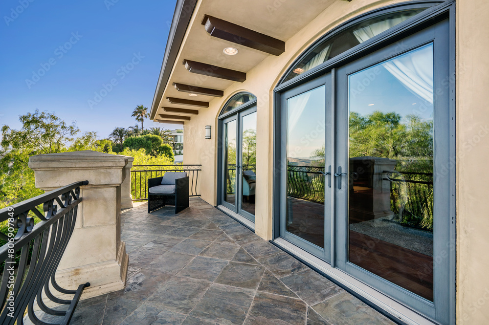 balcony with view to trees, stone patio and chair with black iron railing balcony with view to trees, stone patio and chair with black iron railing