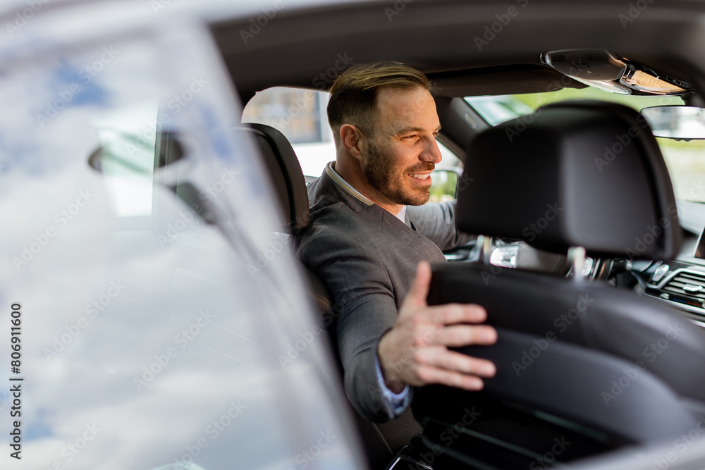 Welcoming smile from a joyful driver in a luxury sedan on a sunny day Welcoming smile from a joyful driver in a luxury sedan on a sunny day