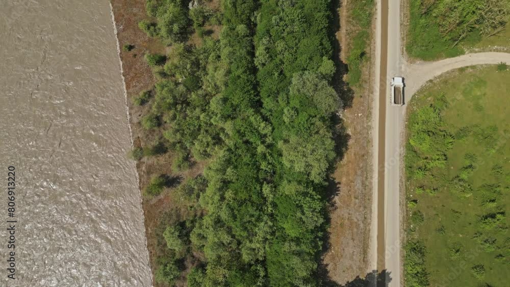 truck rides along a river in a valley in the mountains, aerial view from above truck rides along a river in a valley in the mountains, aerial view from above