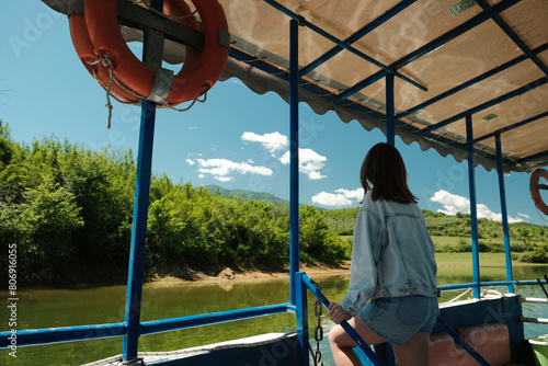 Happy young female tourist traveling by boat on the lake Kerkini, Greece photo