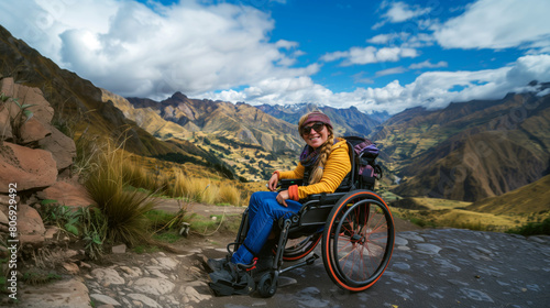 Happy woman in a wheelchair enjoying a scenic mountain landscape on a sunny day. © Natalia