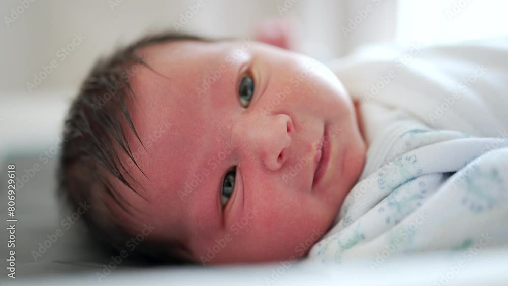 Newborn baby close-up face capturing the first days o flife life of an infant observing the world around him, first week of life Newborn baby close-up face capturing the first days o flife life of an infant observing the world around him, first week of life