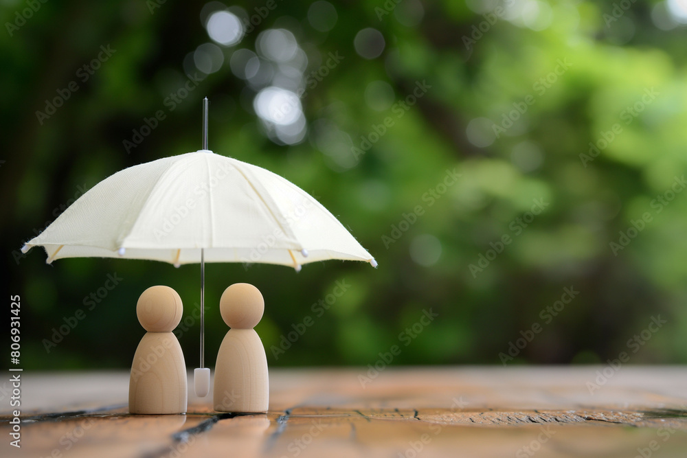 custom made wallpaper toronto digitalWhite umbrella sheltering two wooden figurines, set against a blurred natural backdrop, protection or insurance. Security and care, concepts related to safety or family protection in advertising.