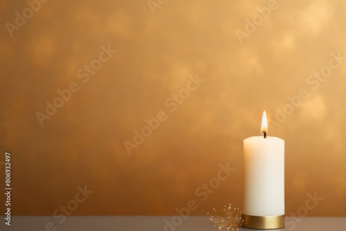 Gold background with white thin wax candle with a small lit flame for funeral grief death dead sad emotion with copy space texture for display 