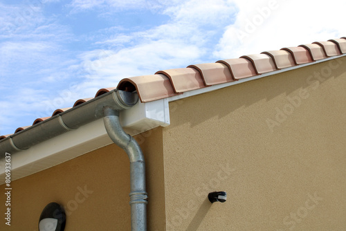 Gouttière zinc gris sur la façade de la maison, descentes et lambris de sous-face en PVC blanc 
