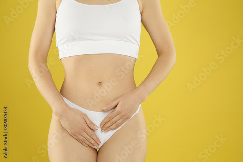 Gynecology. Woman in underwear on yellow background, closeup. Space for text © New Africa