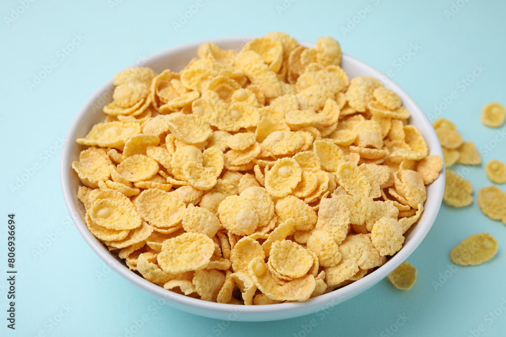 Breakfast cereal. Tasty corn flakes in bowl on light blue table, closeup Breakfast cereal. Tasty corn flakes in bowl on light blue table, closeup