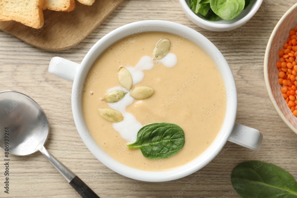 Healthy cream soup high in vegetable fats served on wooden table, flat lay Healthy cream soup high in vegetable fats served on wooden table, flat lay
