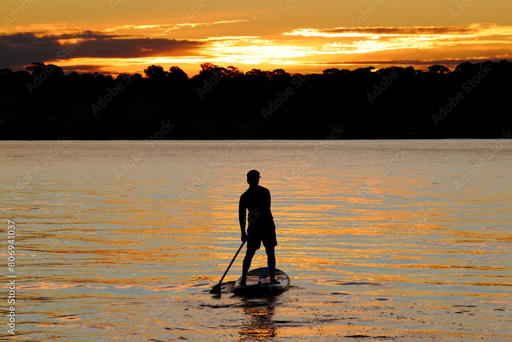 Silhouette of young man, stand up (SUP) paddle board, sunset, Swan River, Perth, Western Australia