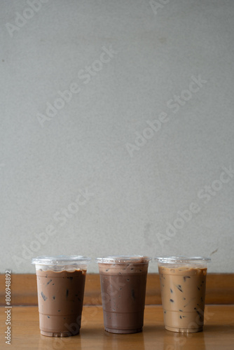 Take away plastic cup of iced chocolate, iced mocha and iced latte on table with copy space