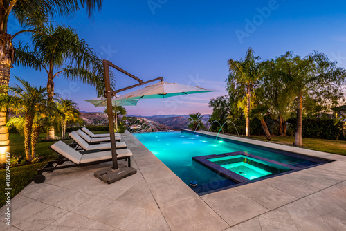 a beautiful swimming area with white lounge chairs next to the pool