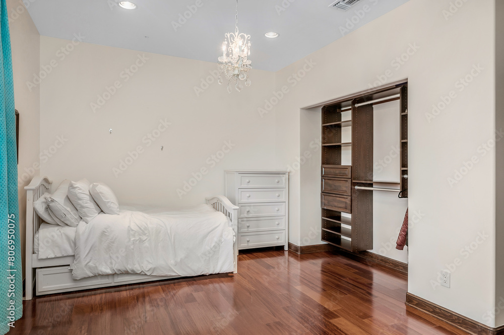 Fototapeta premium a white bed sitting on top of a wooden floor next to a closet
