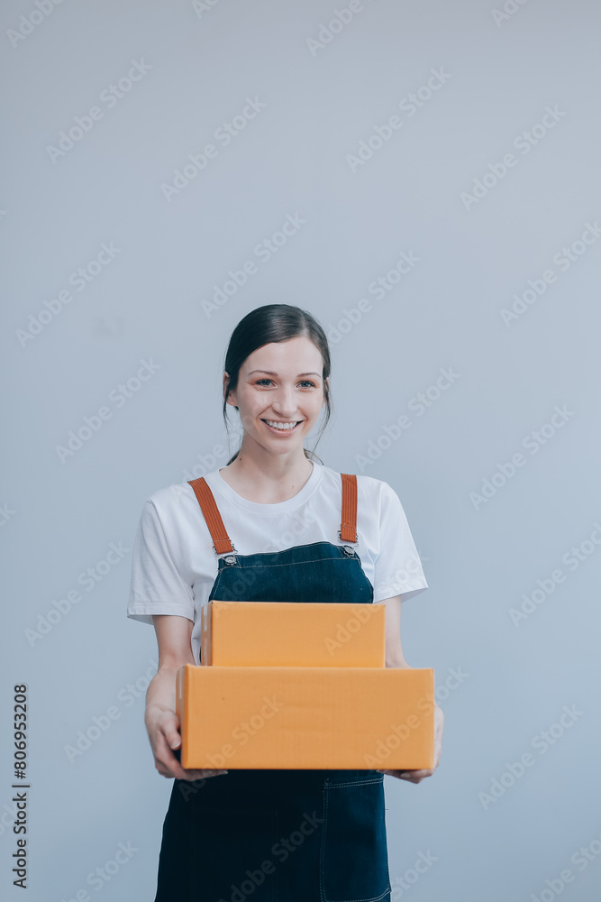 Smiling Asian woman in casual clothes holding a cardboard box mockup while standing against an isolated white background. shipping business concept Smiling Asian woman in casual clothes holding a cardboard box mockup while standing against an isolated white background. shipping business concept