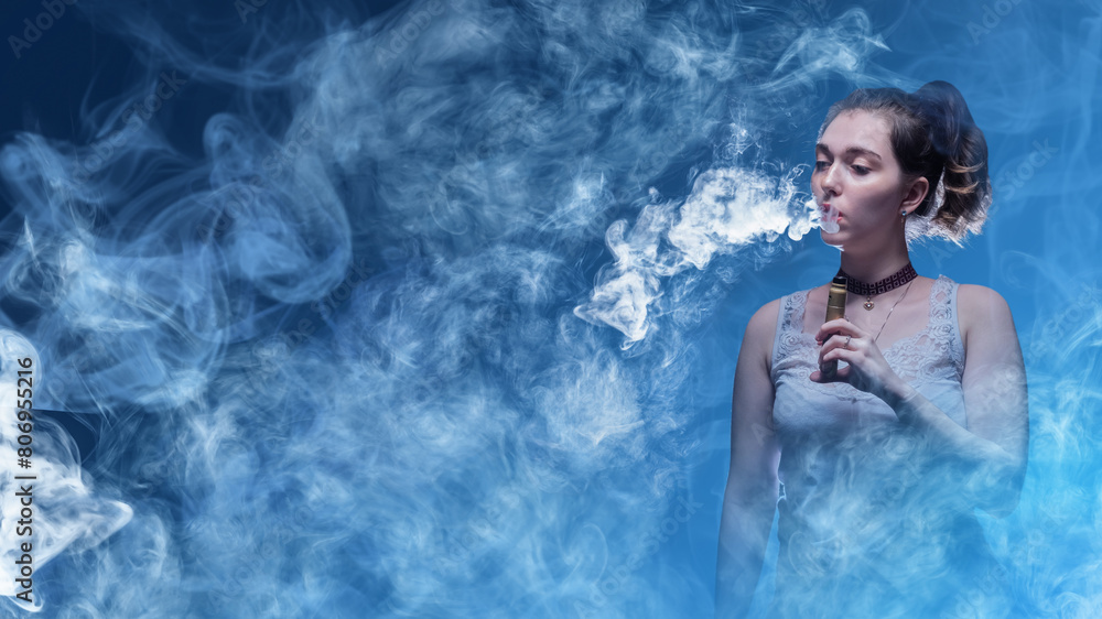 Woman smokes vape. Vaper girl stands in smoke. Lady with electronic cigarette. Young woman holding vape pen. Vaper blows smoke from his mouth. Female enjoys vaping. Relaxed girl using vape device