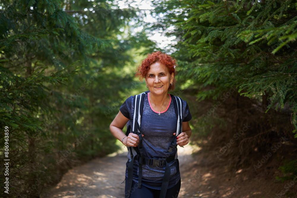Woman hiker with backpack in a pine forest Woman hiker with backpack in a pine forest