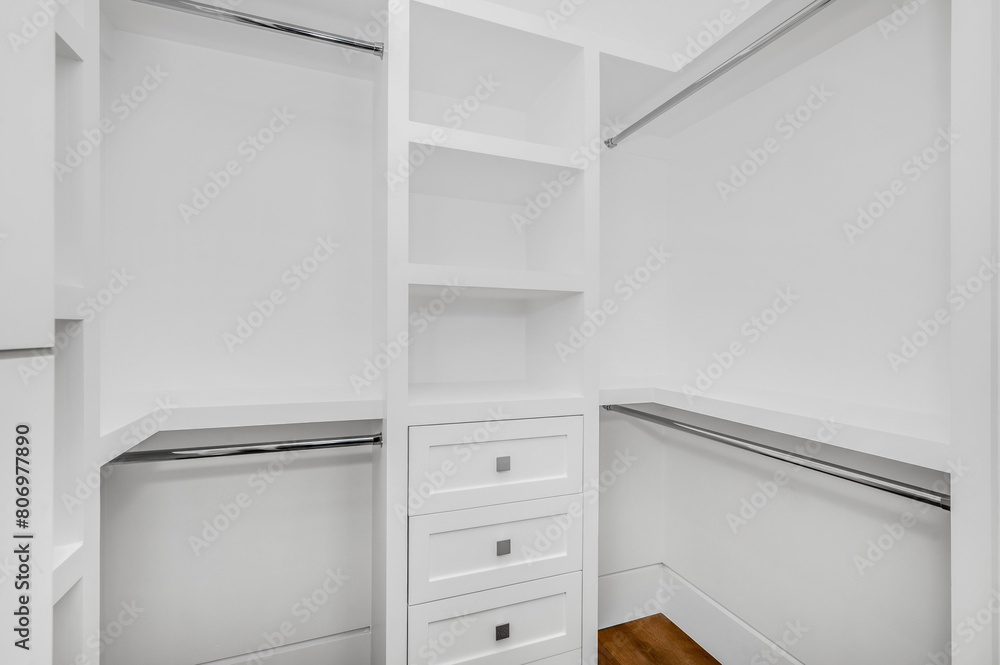 an empty closet with white shelves and white cabinets and a drawer an empty closet with white shelves and white cabinets and a drawer