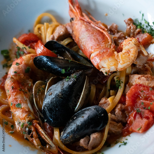 spaghetti with shrimos, mussels and sauce in a plate