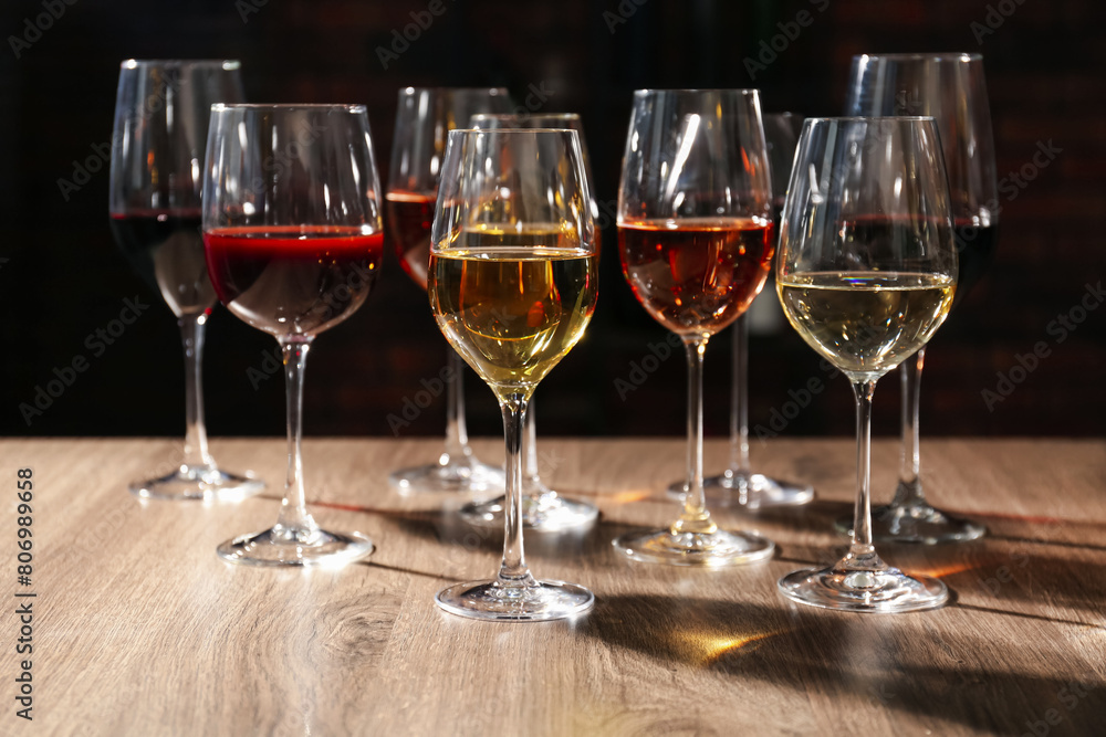 Different tasty wines in glasses on wooden table Different tasty wines in glasses on wooden table